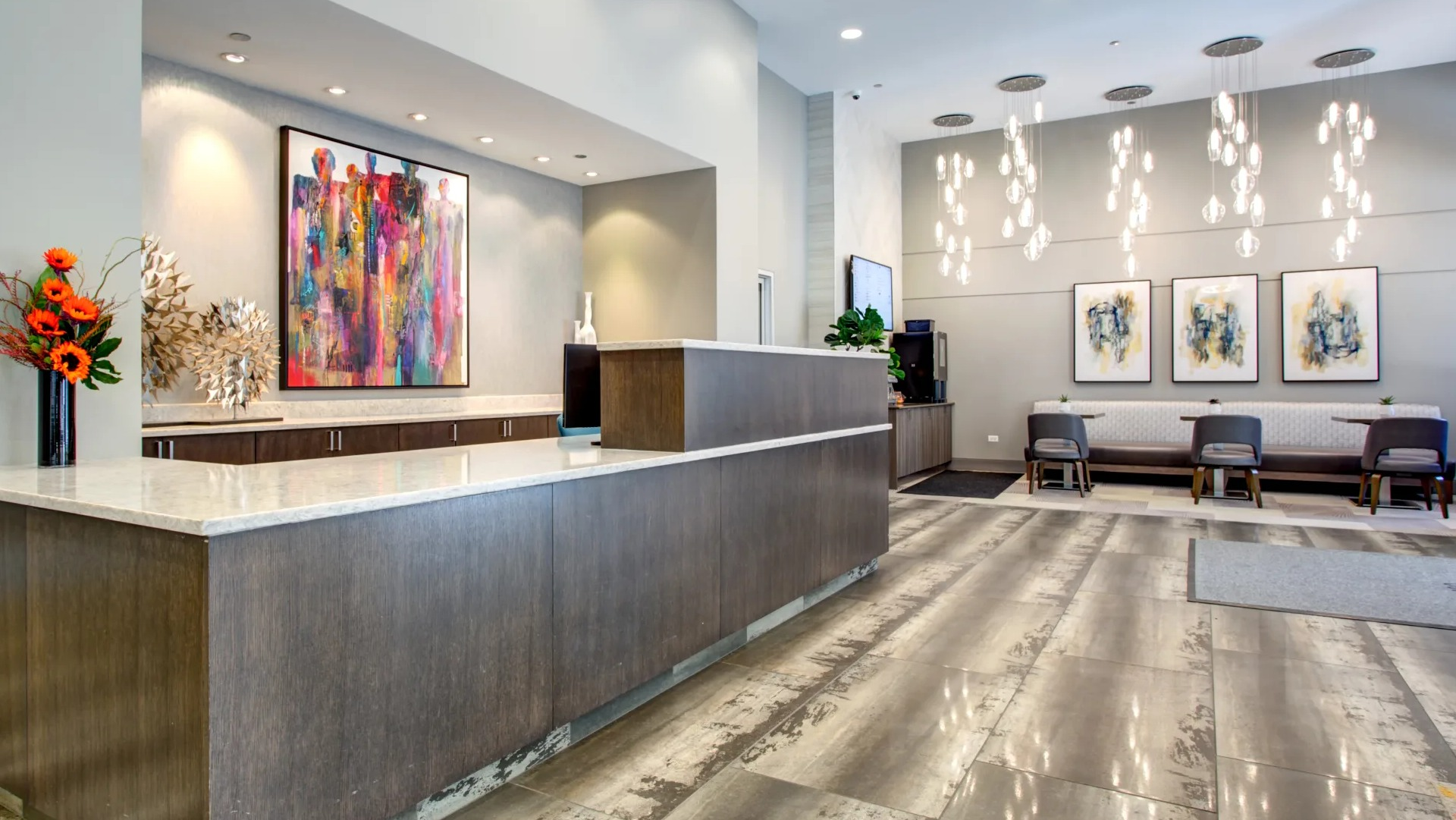 Hotel-style lobby with concierge desk, modern art and statement lighting offering a welcoming arrival at 180 North Jefferson apartments in Chicago