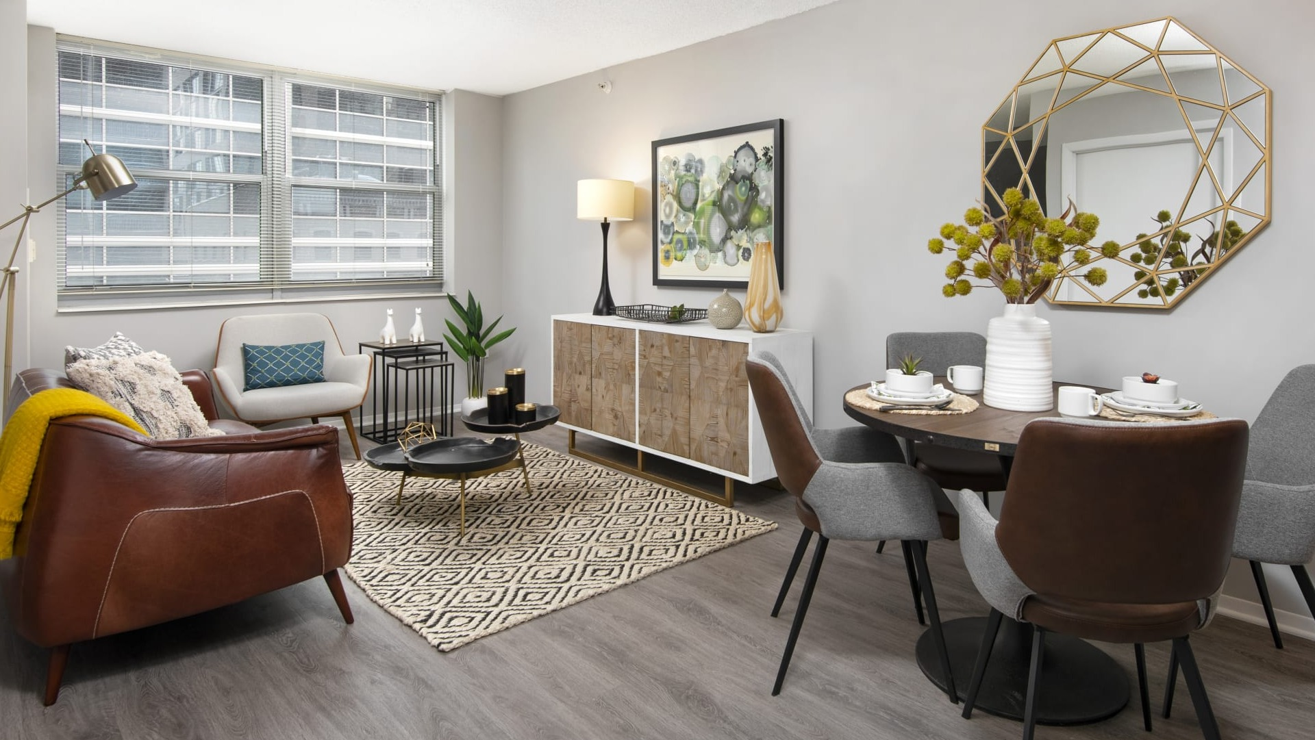 Open-concept living and dining area with large windows, mid-century decor and wood floors at 180 North Jefferson apartments in Chicago