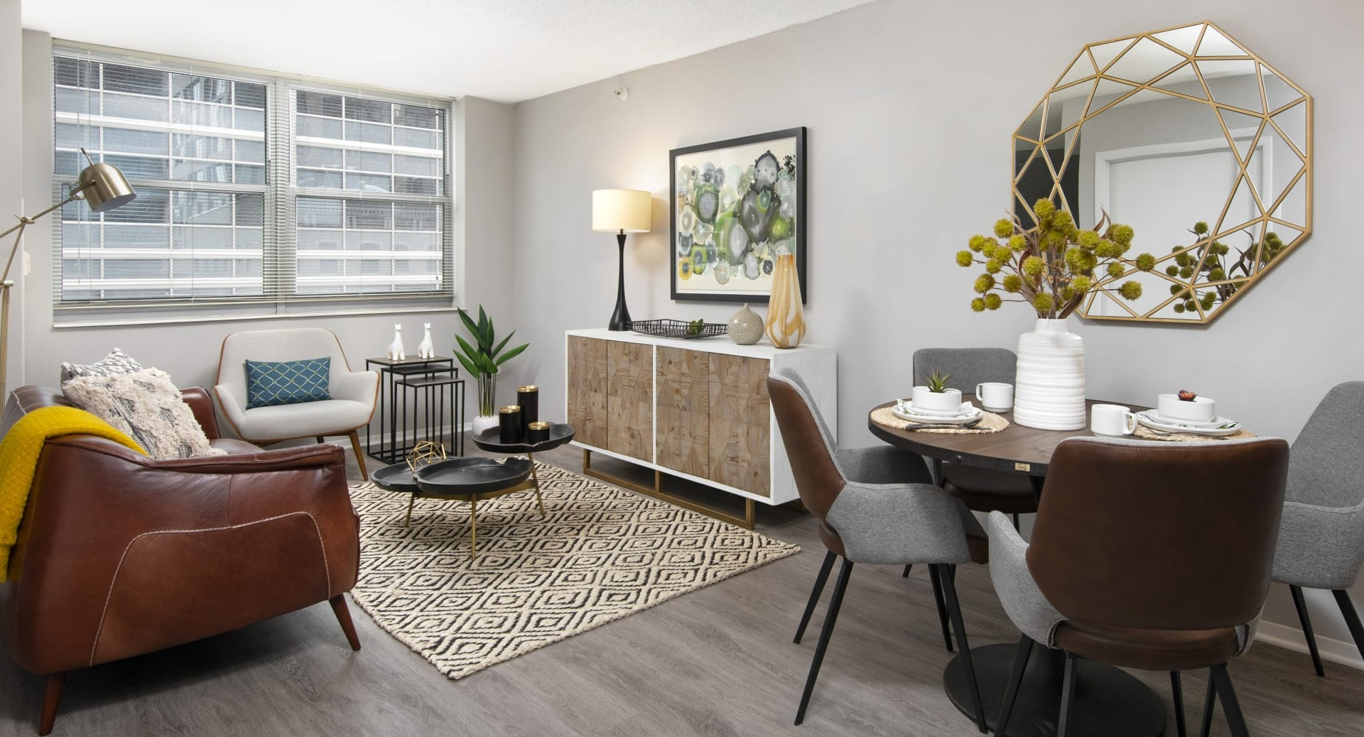 Open-concept living and dining area with large windows, mid-century decor and wood floors at 180 North Jefferson apartments in Chicago