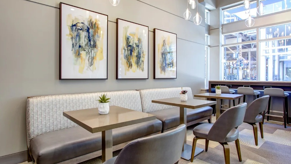 Resident cafe seating with banquette, small tables and pendant lights near the lobby at 180 North Jefferson apartments in Chicago