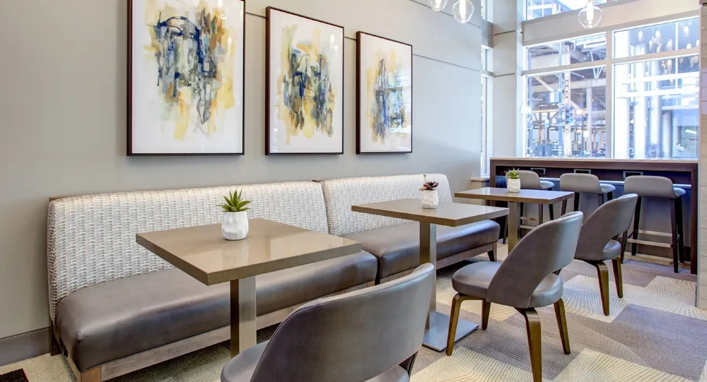 Resident cafe seating with banquette, small tables and pendant lights near the lobby at 180 North Jefferson apartments in Chicago