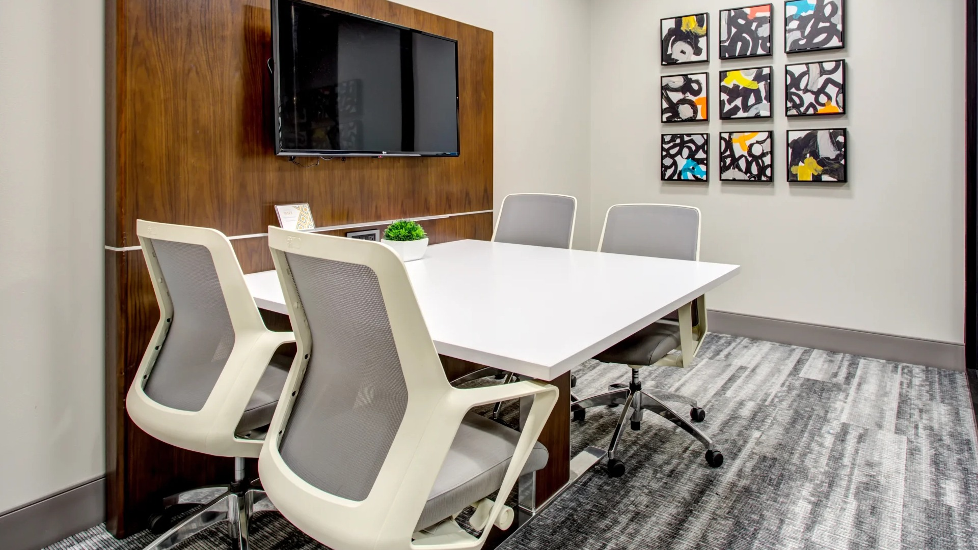 Resident conference room with TV, glass wall and modern chairs ideal for work from home at 180 North Jefferson apartments in Chicago