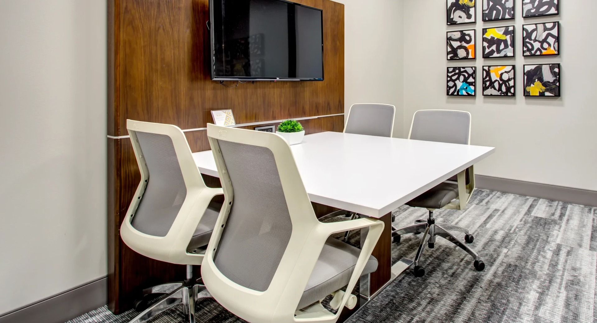 Resident conference room with TV, glass wall and modern chairs ideal for work from home at 180 North Jefferson apartments in Chicago