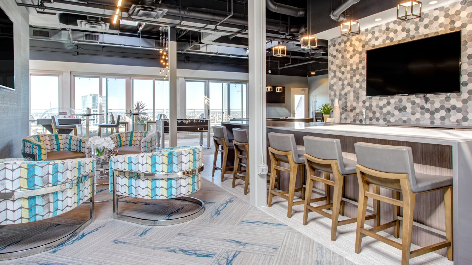 Rooftop resident lounge with bar seating, modern lighting and skyline views perfect for entertaining at 180 North Jefferson apartments in Chicago