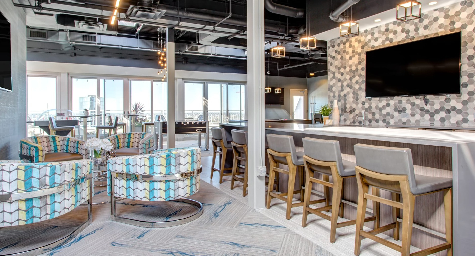 Rooftop resident lounge with bar seating, modern lighting and skyline views perfect for entertaining at 180 North Jefferson apartments in Chicago