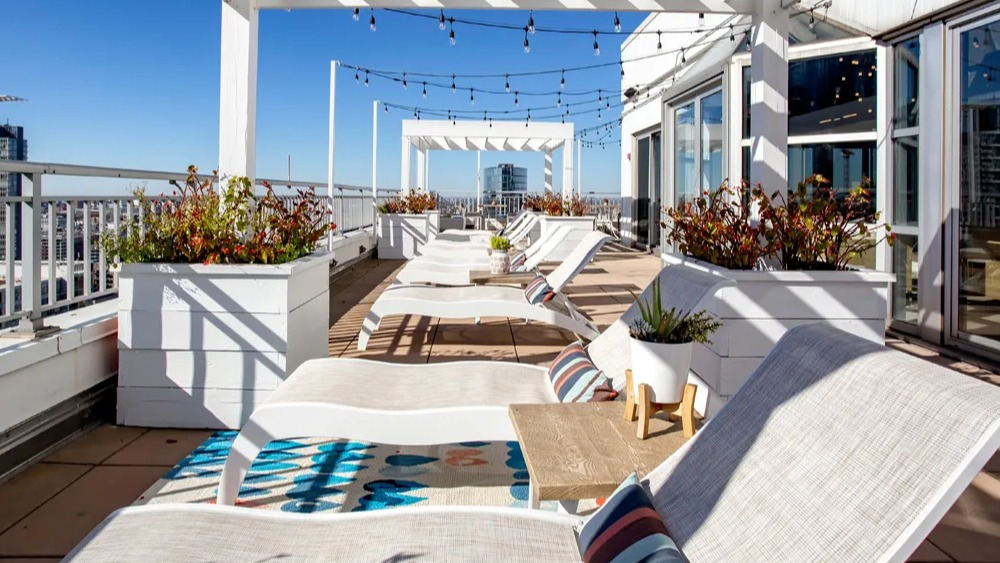 Sundeck with pergolas, lounge chairs and planters along the rooftop terrace at 180 North Jefferson apartments in Chicago