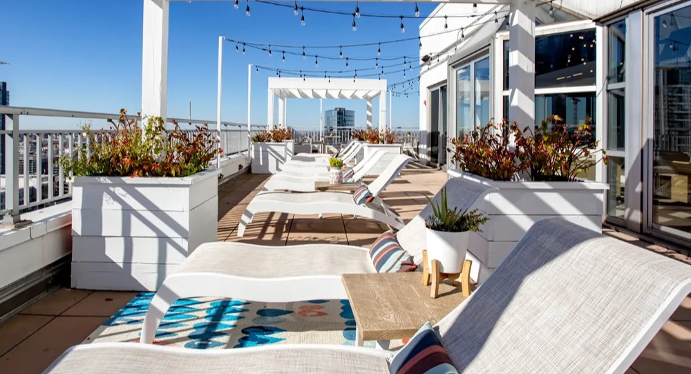 Sundeck with pergolas, lounge chairs and planters along the rooftop terrace at 180 North Jefferson apartments in Chicago