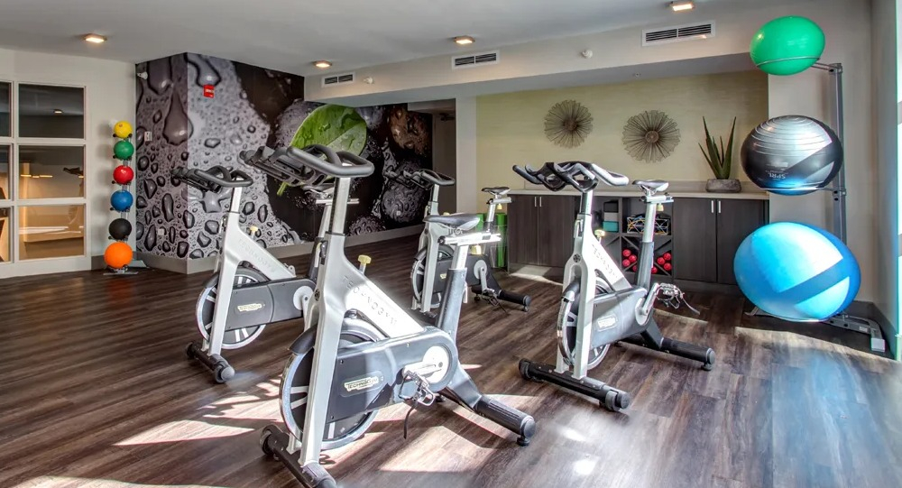 Bright spin and yoga studio with stationary bikes, mirrored wall and workout accessories at 180 North Jefferson apartments in Chicago