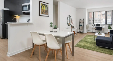 Open-concept layout with modern kitchen, dining for four, and bright living room with home office area at 20 E Scott apartments in Chicago