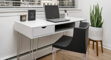 Work-from-home nook with white desk, modern chair, potted plant, and large window views at 20 E Scott apartments in Chicago