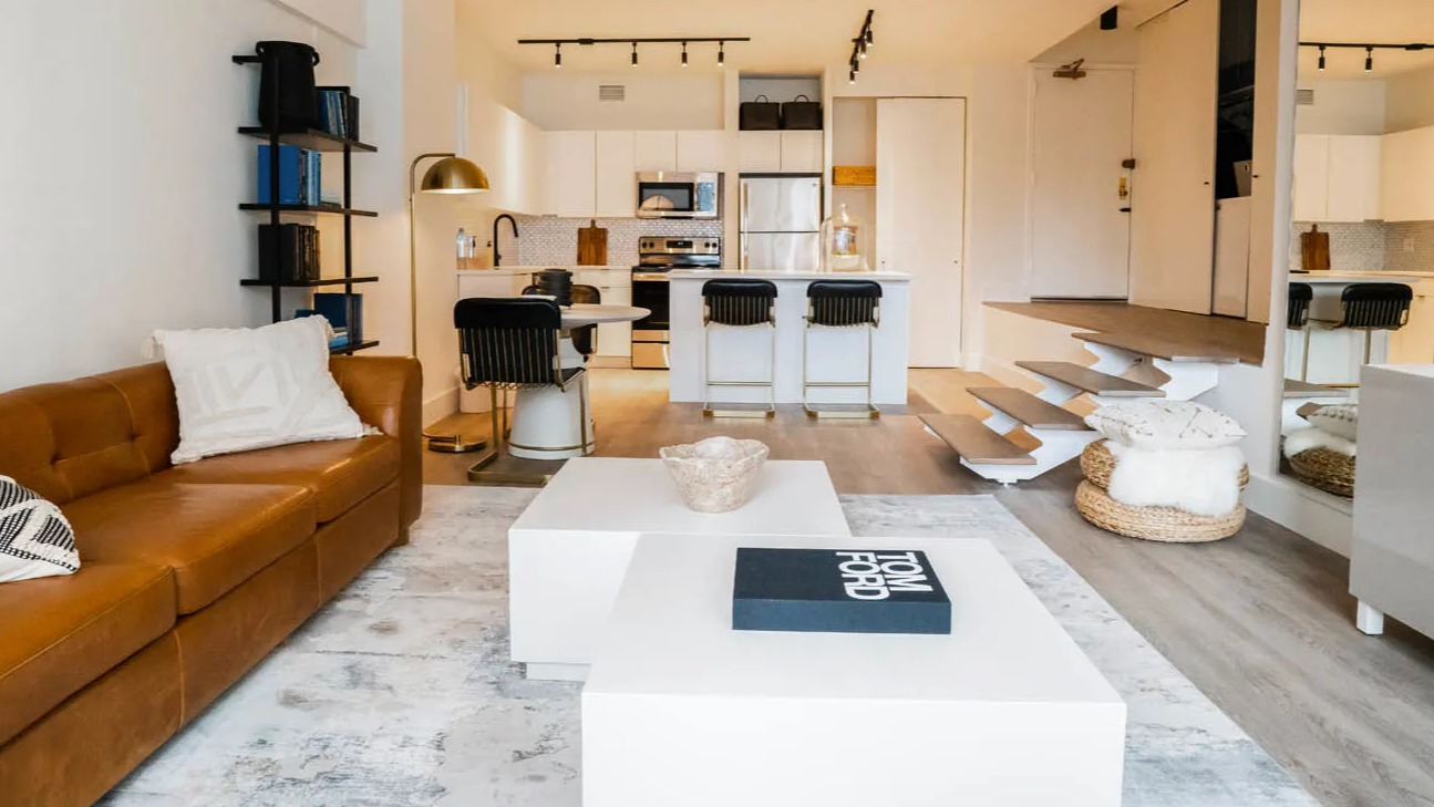 Cozy living area with leather sofa, twin lounge chairs, large windows, and layered rugs at 21 E Chestnut apartments in downtown Chicago