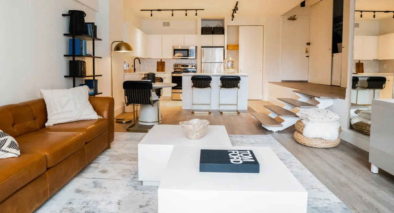 Cozy living area with leather sofa, twin lounge chairs, large windows, and layered rugs at 21 E Chestnut apartments in downtown Chicago