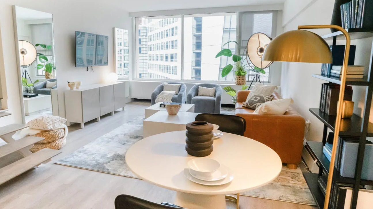 Open-concept living and dining area with round table, bookshelf, and modern lighting at 21 E Chestnut apartments in Chicago