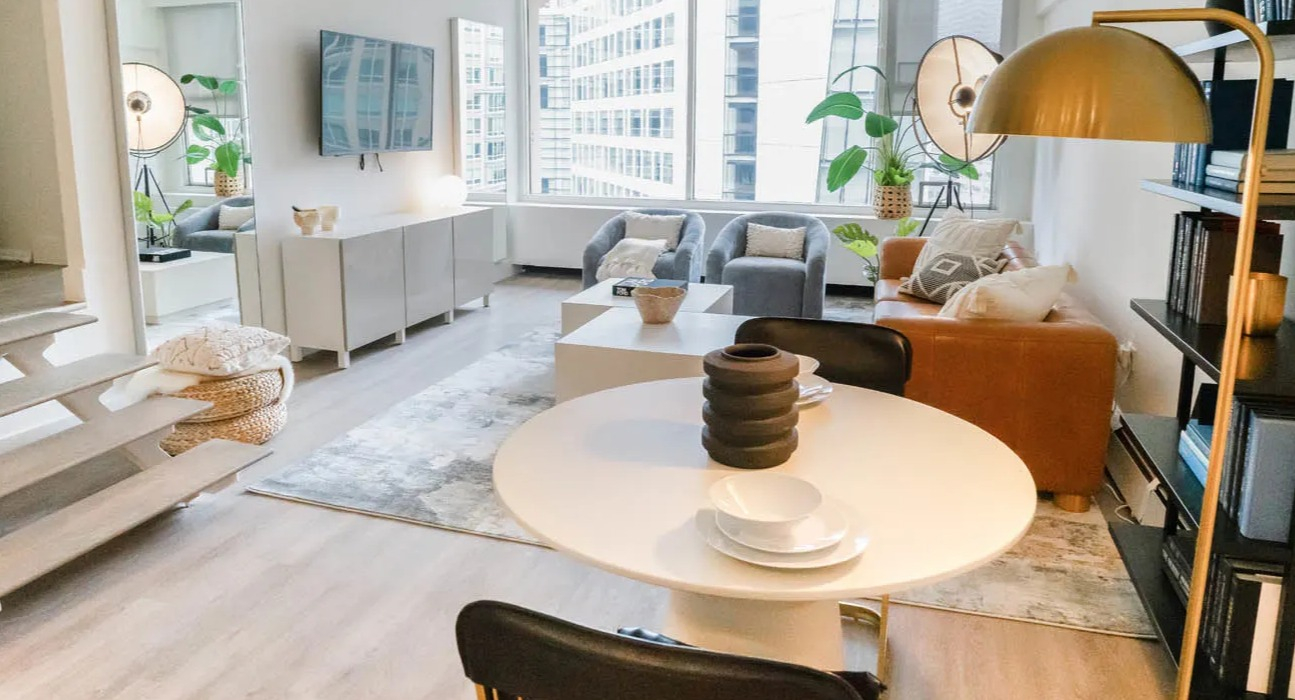 Open-concept living and dining area with round table, bookshelf, and modern lighting at 21 E Chestnut apartments in Chicago