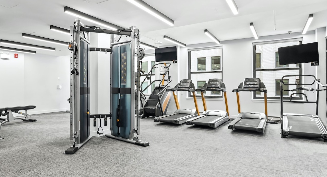 Fitness center at 330 S Wells Apartments in Chicago with cardio machines, weight equipment, and bright windows