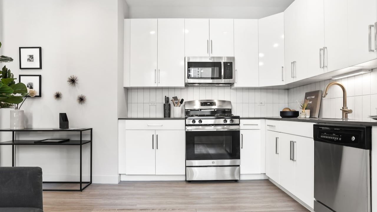 Modern kitchen area at 330 S Wells Apartments in Chicago with stainless steel appliances, white cabinets, and sleek finishes