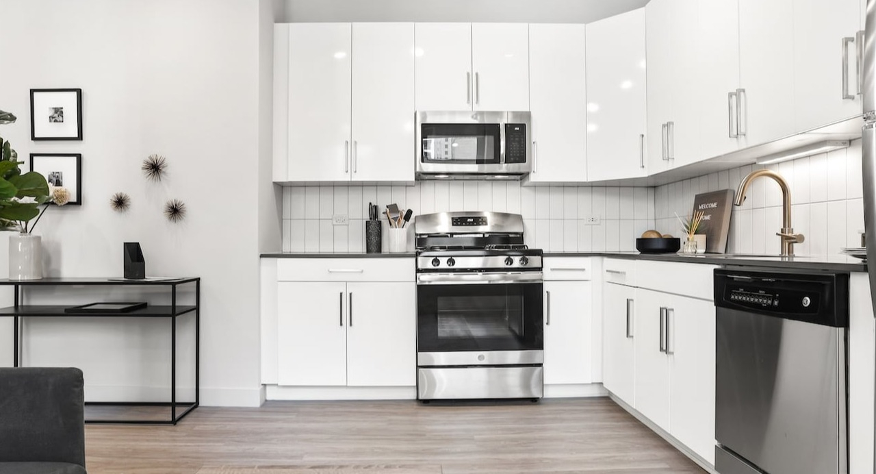 Modern kitchen area at 330 S Wells Apartments in Chicago with stainless steel appliances, white cabinets, and sleek finishes