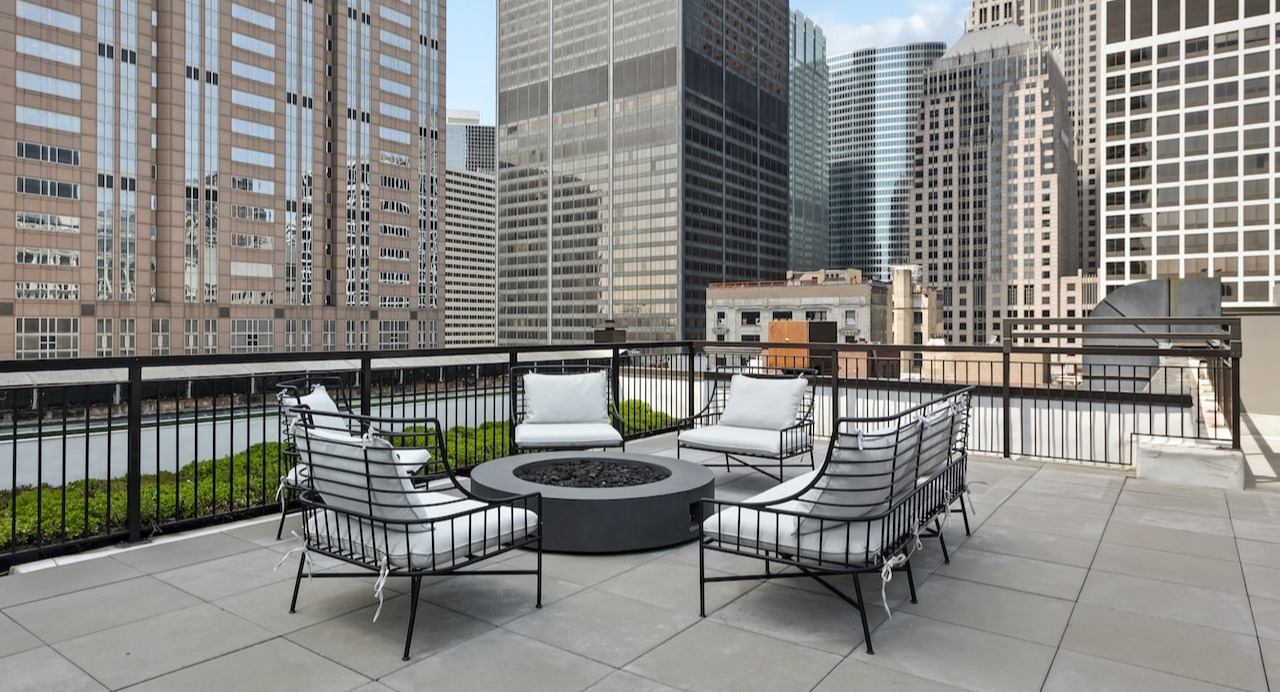 Rooftop firepit lounge at 330 S Wells Apartments in Chicago with cushioned seating and city skyline views