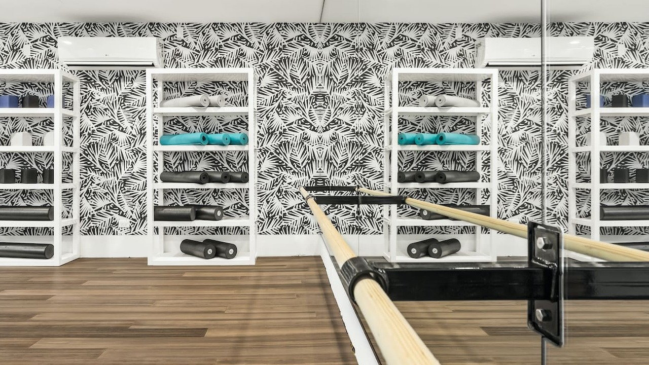 Yoga and wellness room at 330 S Wells Apartments in Chicago with mirrored wall, wood flooring, and fitness equipment