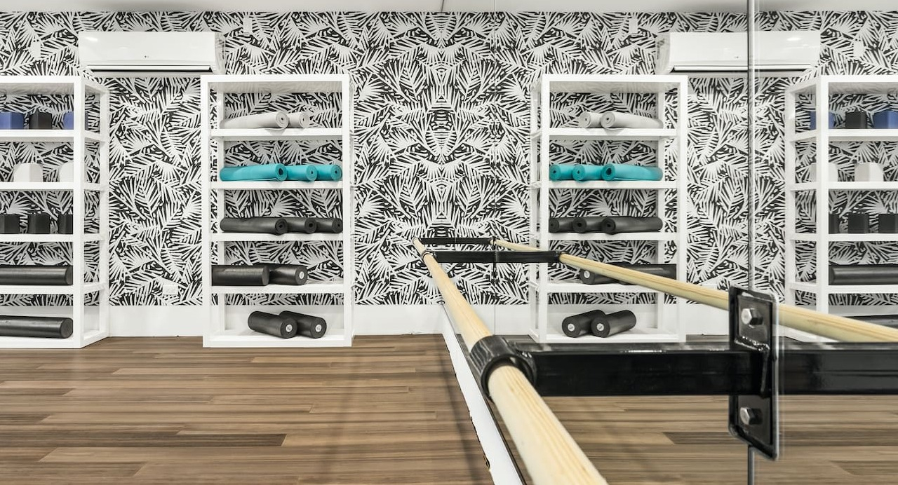 Yoga and wellness room at 330 S Wells Apartments in Chicago with mirrored wall, wood flooring, and fitness equipment