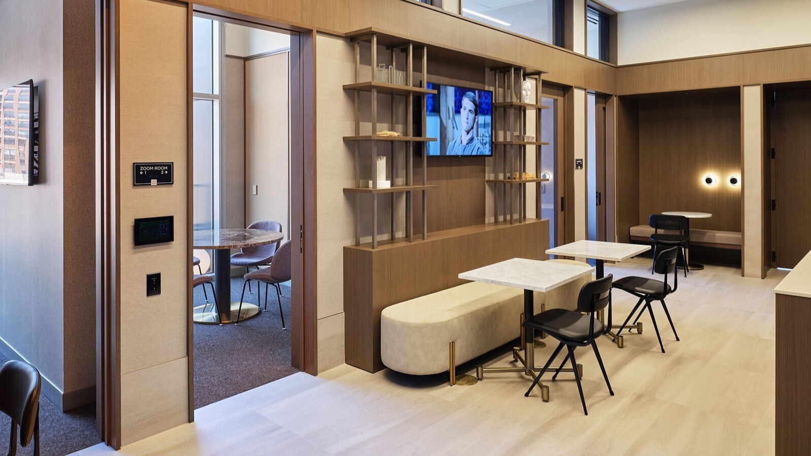 Coworking lounge with private Zoom rooms, cafe tables, and built-in shelving designed for remote work at 369 Grand apartments in Chicago