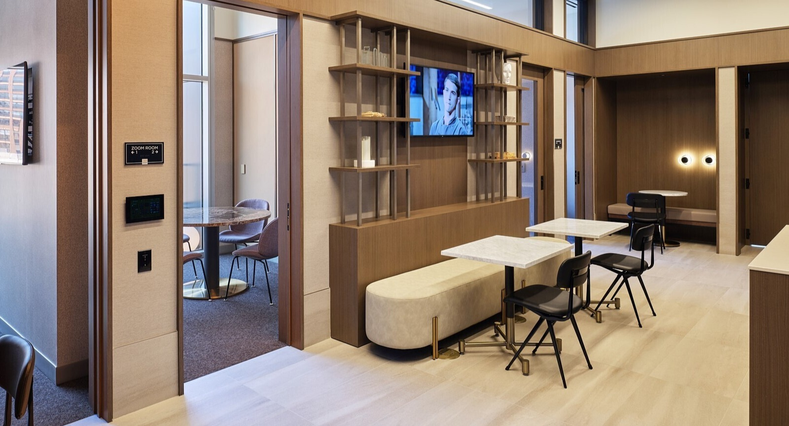 Coworking lounge with private Zoom rooms, cafe tables, and built-in shelving designed for remote work at 369 Grand apartments in Chicago