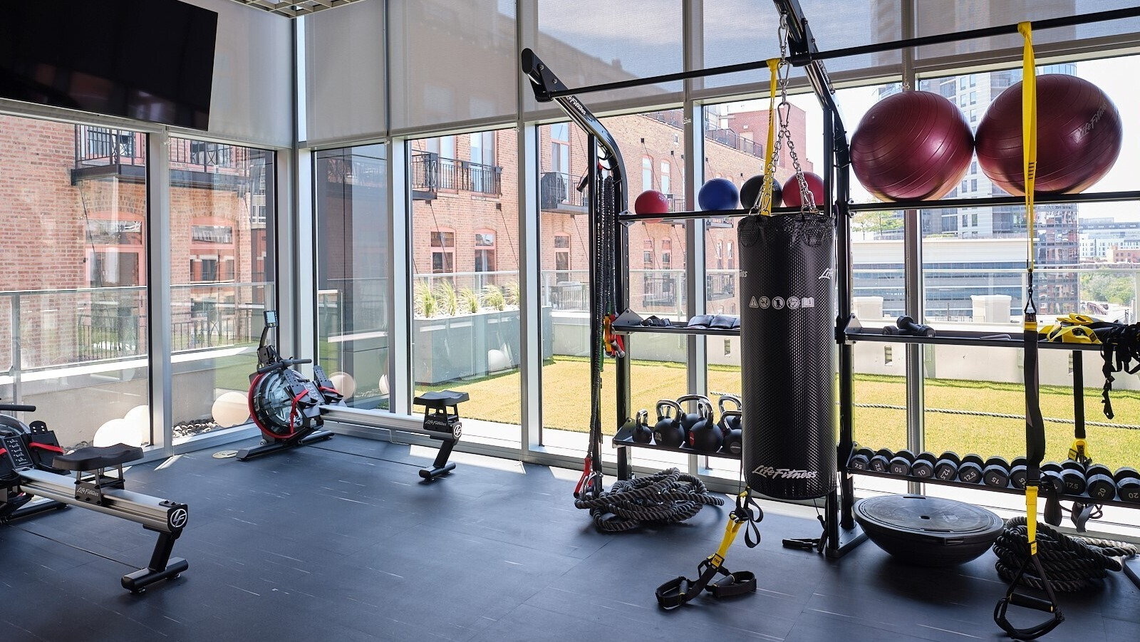 Functional training zone with squat rack, kettlebells, medicine balls, rowing machines, and a heavy bag at 369 Grand apartments in Chicago