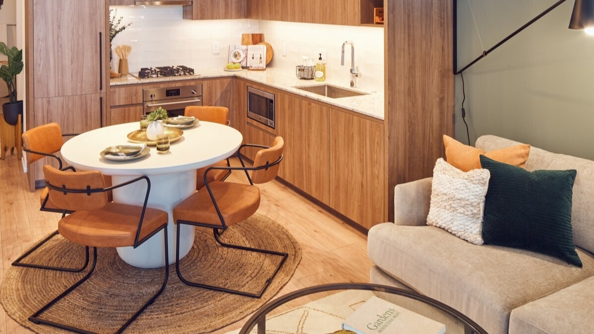 Modern L-shaped kitchen with integrated appliances, stone countertops, and an oval dining set at 369 Grand apartments in Chicago