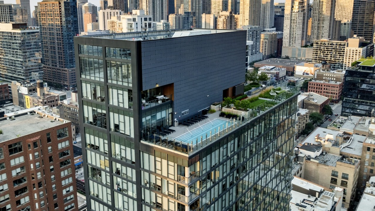 Aerial view of 3Eleven Luxury Apartments in Chicago showcasing modern glass design, rooftop pool, and landscaped outdoor terrace