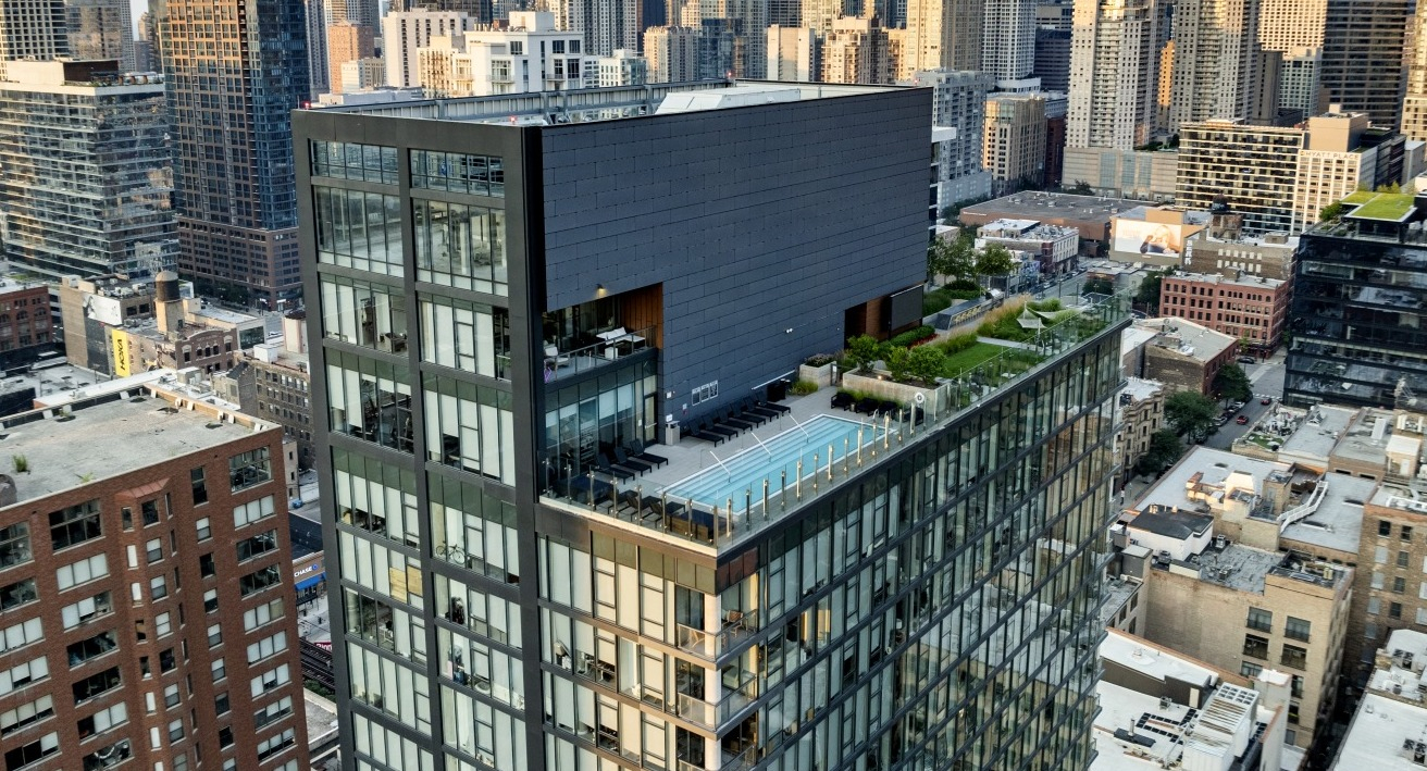 Aerial view of 3Eleven Luxury Apartments in Chicago showcasing modern glass design, rooftop pool, and landscaped outdoor terrace