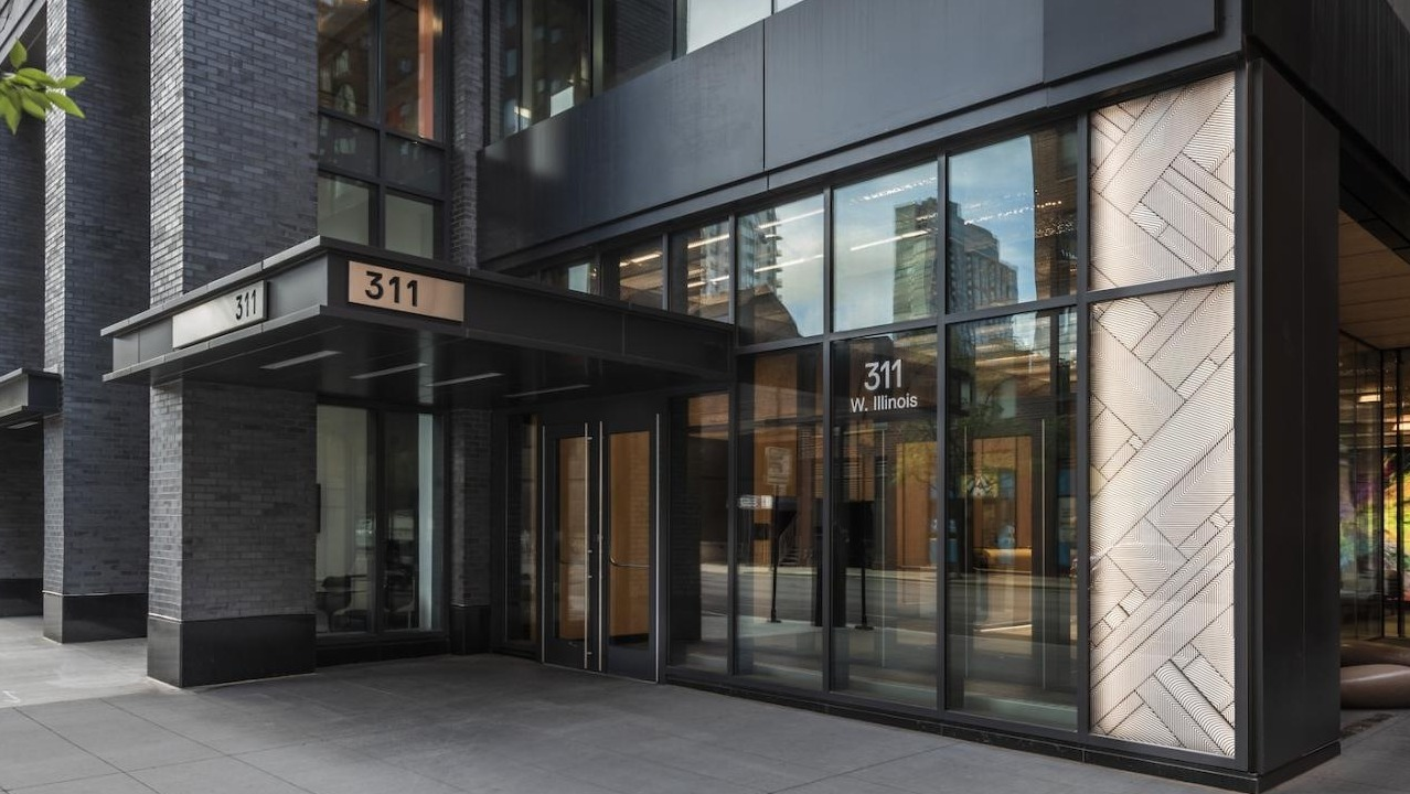 Street-level entrance of 3Eleven Luxury Apartments in Chicago with sleek black exterior, large glass windows, and modern lobby design