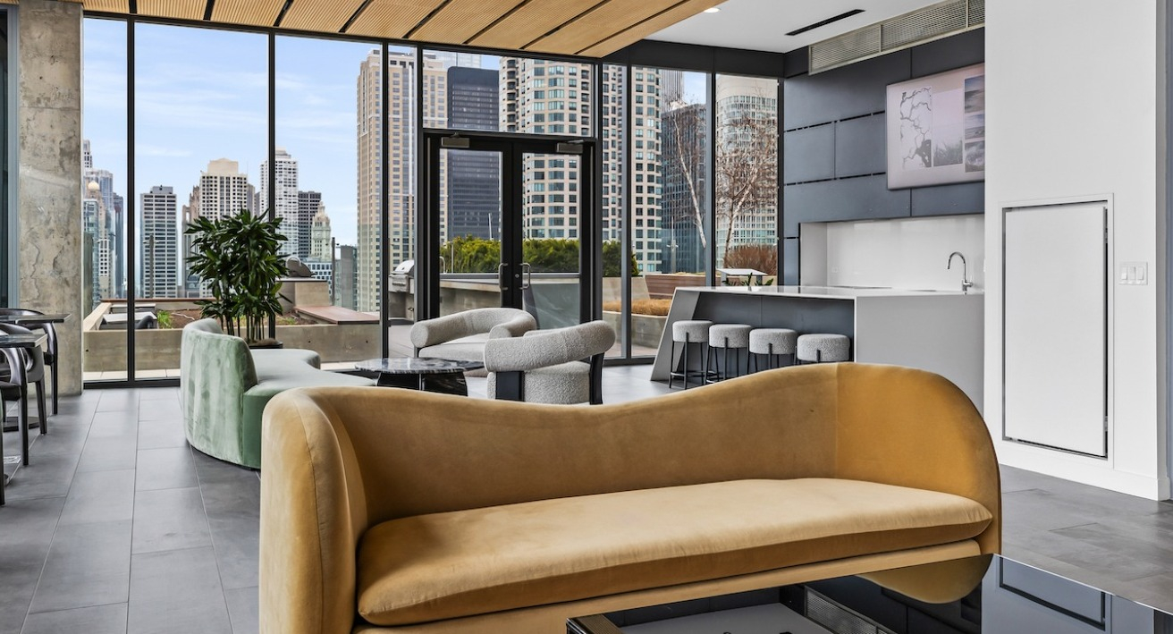 Resident lounge at 3Eleven Luxury Apartments in Chicago featuring cozy seating, large windows, and skyline views