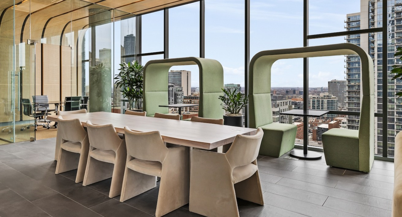 Modern meeting room with long table and lounge seating at 3Eleven Luxury Apartments in Chicago with city views