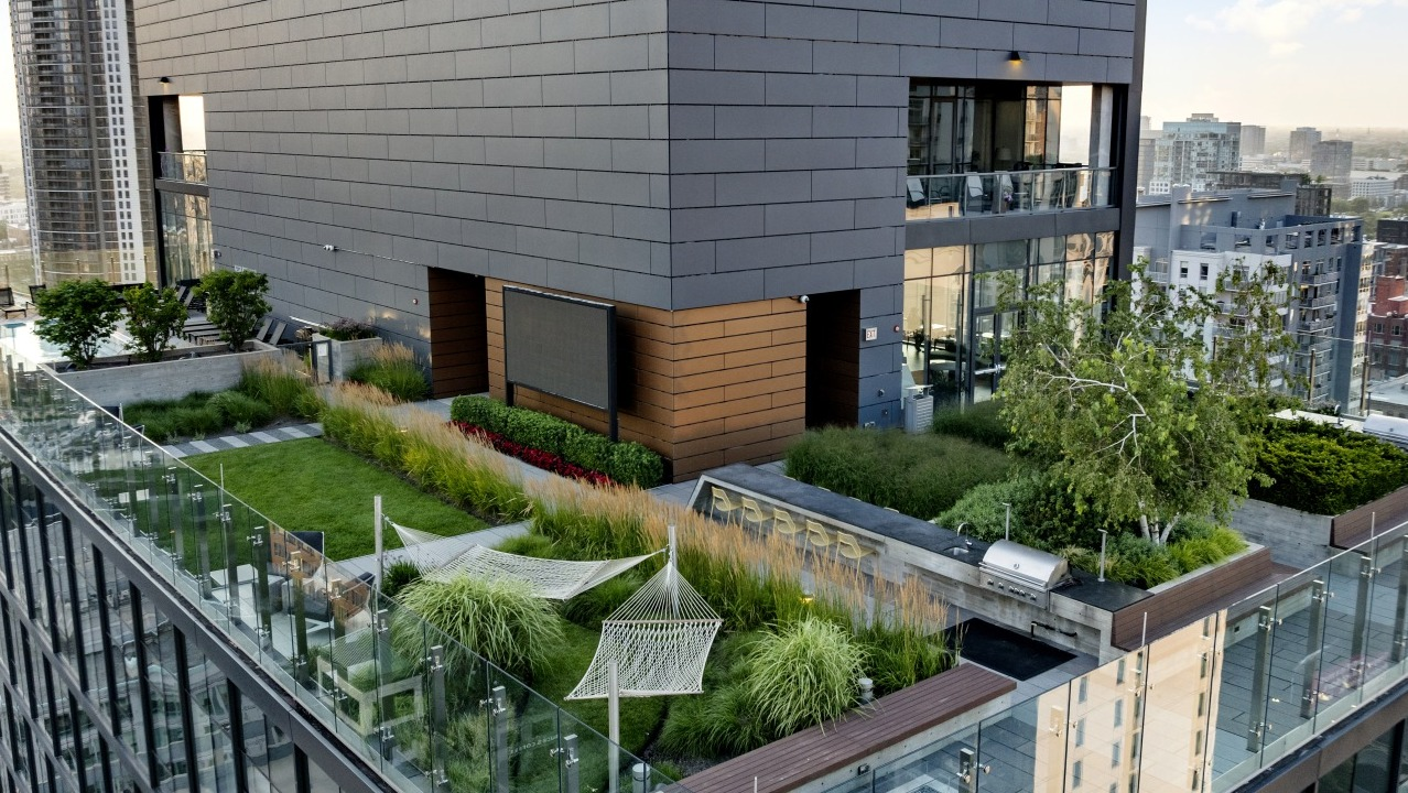 Rooftop garden at 3Eleven Luxury Apartments in Chicago featuring hammocks, lounge areas, outdoor grill, and landscaped greenery with skyline views