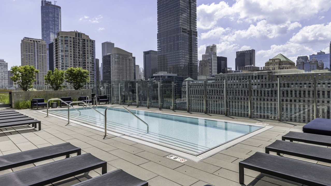 Rooftop swimming pool at 3Eleven Luxury Apartments in Chicago with lounge seating and panoramic views of the downtown skyline