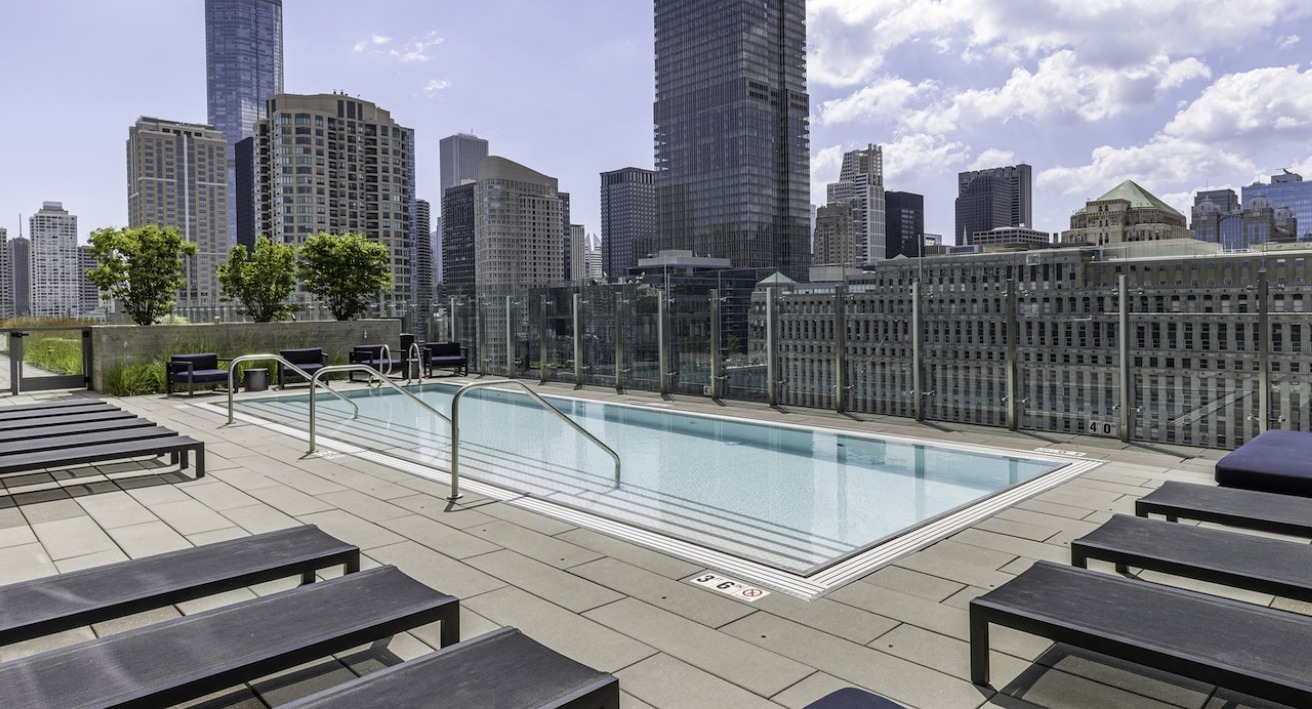 Rooftop swimming pool at 3Eleven Luxury Apartments in Chicago with lounge seating and panoramic views of the downtown skyline