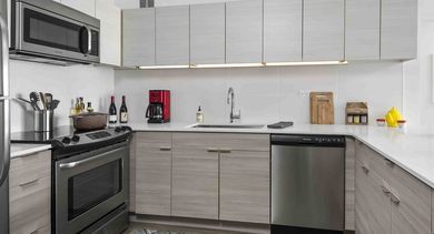 Modern kitchen with stainless steel appliances, sleek cabinetry, and white countertops at 420 East Ohio apartments in Chicago, designed for style and convenience