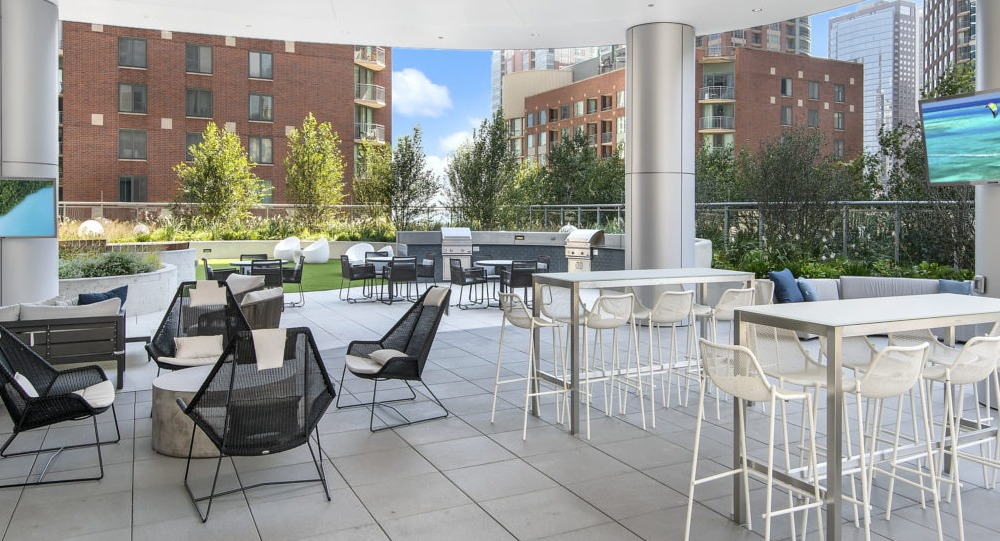 Covered outdoor lounge with dining tables and modern seating at 465 North Park apartments in Chicago
