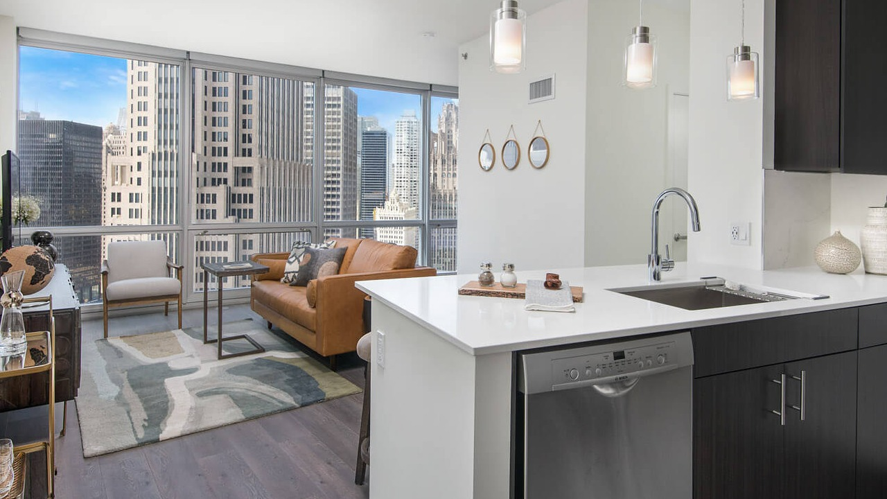 Kitchen and living room with modern finishes, pendant lighting, and skyline views at 465 North Park apartments in Chicago