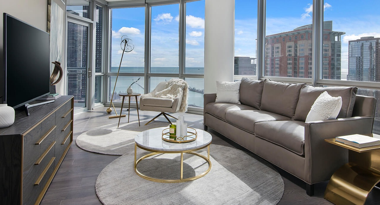 Modern living room with leather sofa, large windows, and lake views at 465 North Park apartments in Chicago
