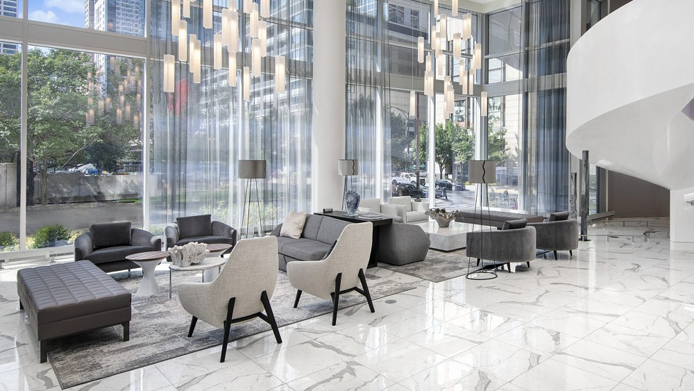 Spacious lobby with marble floors, elegant seating, and dramatic chandeliers at 465 North Park apartments in Chicago