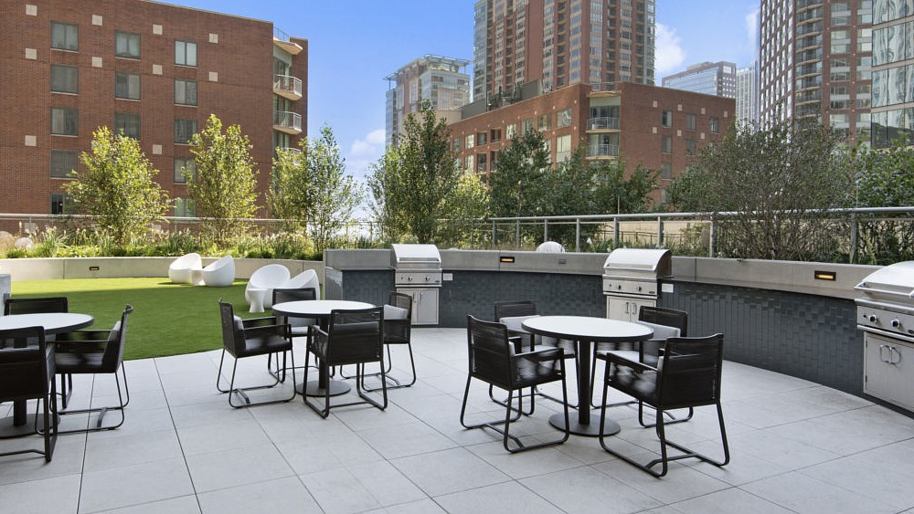 Outdoor grilling station with modern seating and greenery at 465 North Park apartments in Chicago