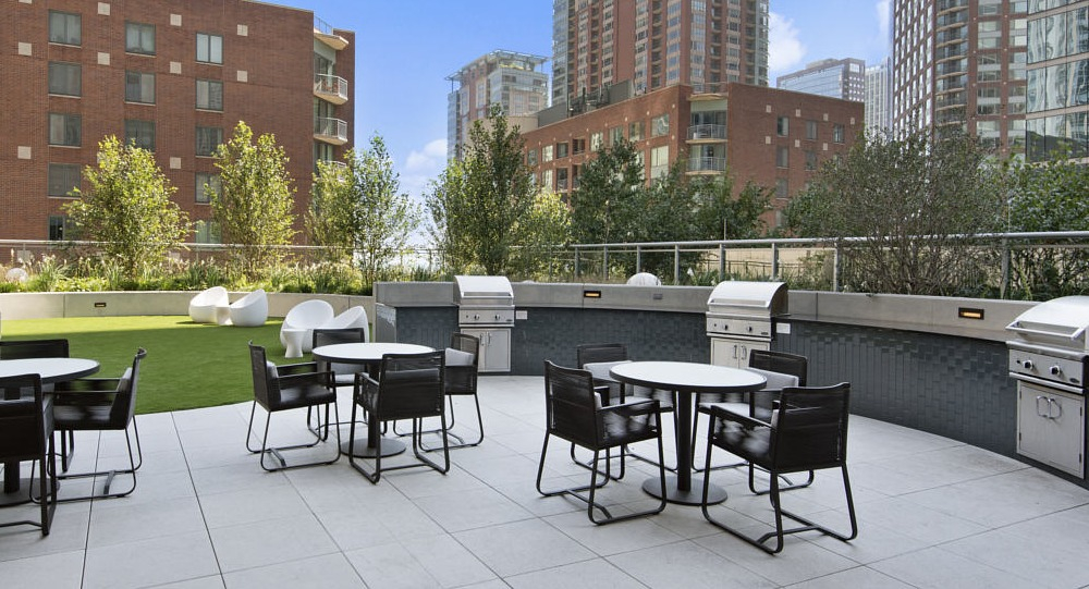 Outdoor grilling station with modern seating and greenery at 465 North Park apartments in Chicago