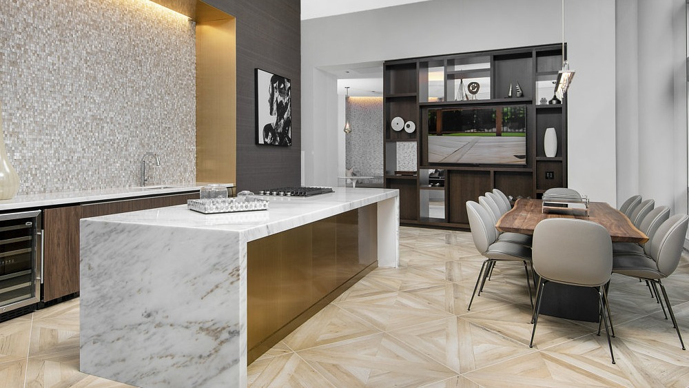 Resident lounge with gourmet kitchen, marble island, and dining area at 465 North Park apartments in Chicago