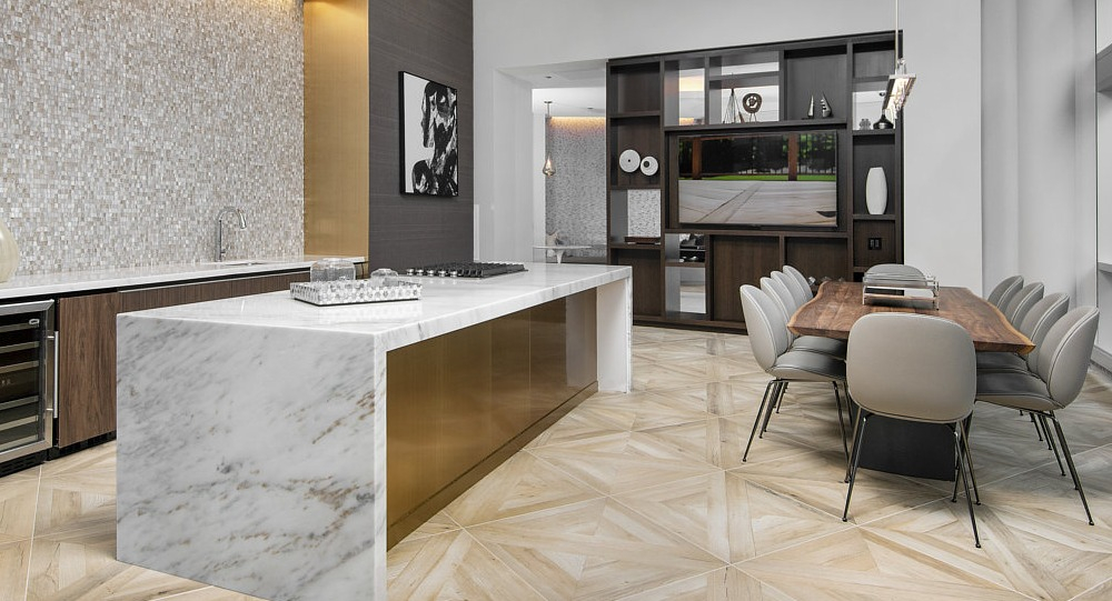 Resident lounge with gourmet kitchen, marble island, and dining area at 465 North Park apartments in Chicago