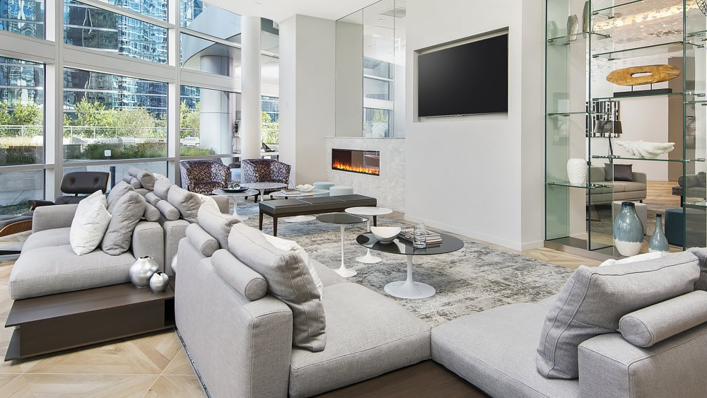 Bright resident lounge with sectional seating, fireplace, and large windows at 465 North Park apartments in Chicago