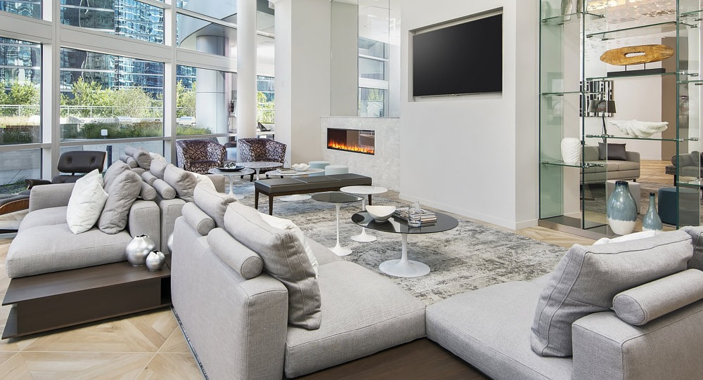 Bright resident lounge with sectional seating, fireplace, and large windows at 465 North Park apartments in Chicago