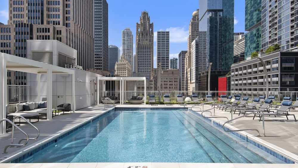 Rooftop swimming pool with lounge chairs and skyline views at 465 North Park apartments in Chicago