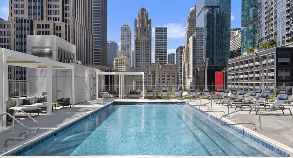 Rooftop swimming pool with lounge chairs and skyline views at 465 North Park apartments in Chicago