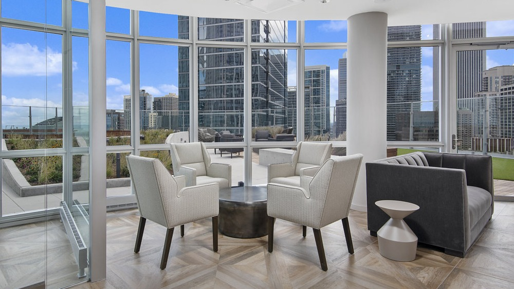 Sky lounge with panoramic views, modern seating, and floor-to-ceiling windows at 465 North Park apartments in Chicago